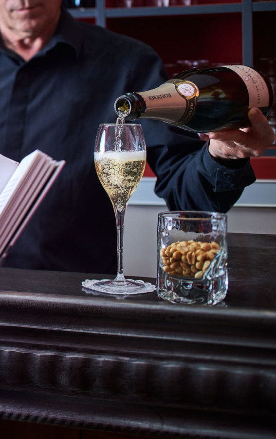 Femme lisant un livre devant le bar de notre Hôtel Paris 6ème – Hôtel Sainte-Beuve